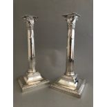 A pair of late Victorian silver corinthian column weighted candlesticks, maker's mark rubbed,