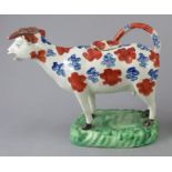 An early nineteenth century pearlware Swansea cow creamer, c.1820. decorated with red and blue
