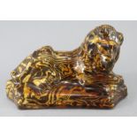 An early nineteenth century Staffordshire earthenware slipware model of a lion , c.1820-30. It is of