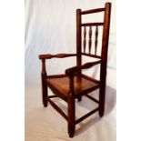 A 19th Century harlequin influence elm child's chair, turned spindle back, single panelled seat,