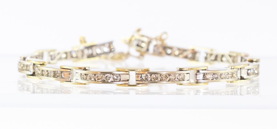 A two colour 18ct gold diamond bracelet of twelve rectangular links, each channel set five brilliant