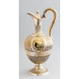 A mid Victorian silver claret jug, urn finial to the hinged cover, scroll handle, bulbous gadroon
