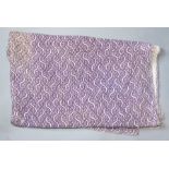 A pale mauve quilted bedspread with a white wavy line and dots in large size, edges slightly frayed,