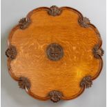 A late 19th Century country house oak lazy susan, C scroll border interspersed with carved bundles