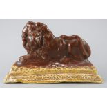 An early nineteenth century Staffordshire brown treacle glaze lion, c.1830-40. It is of moulded form