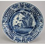 An eighteenth Century tin glazed earthenware plate, blue and white decoration hand-painted with a