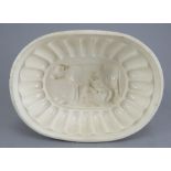 An early nineteenth century creamware jelly mould, c. 1820. It depicts a milkmaid and a cow. 18 cm