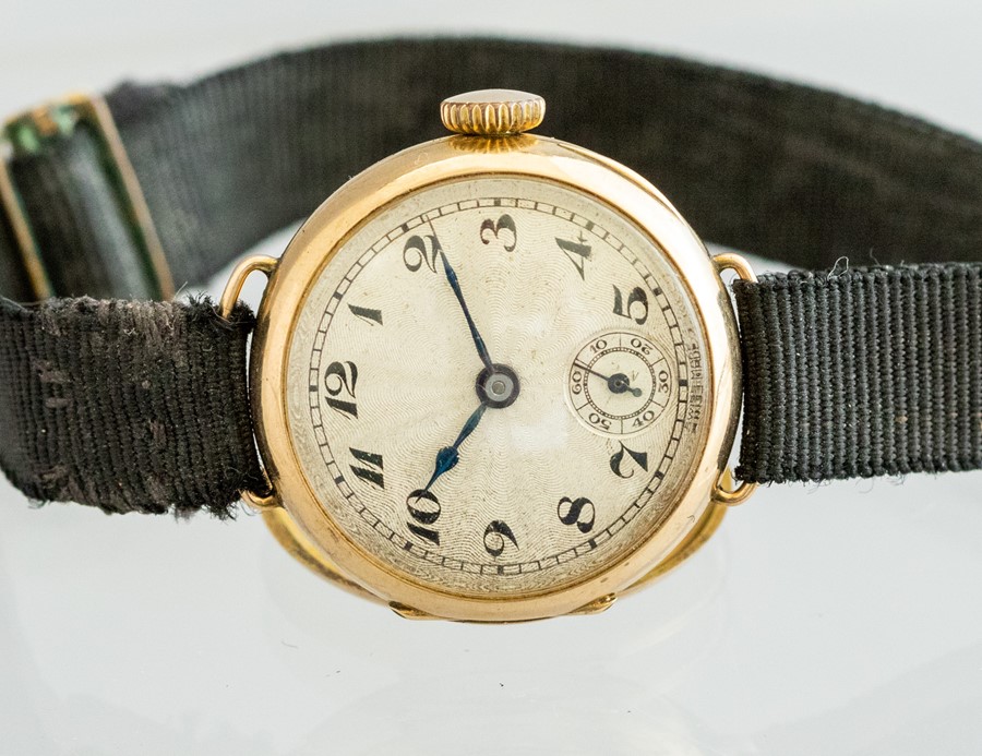 A 1930's ladies 9c gold wristwatch, 2cm circular champagne dial with Arabic numerals, rayon strap