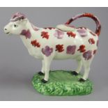 An early nineteenth century creamware Swansea cow creamer, c.1820. It is decorated with red enamel
