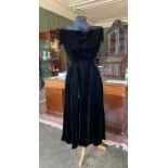 A black velvet Dior dress, 1952-54, the cocktail length dress has a fitted bodice with tiny cap