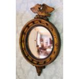 A Regency Irish guiltwood circular mirror, carving of an eagle finial, above a circular moulded