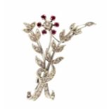 A circa 1950's platinum diamond and ruby set floral spray brooch with eight cut diamonds and