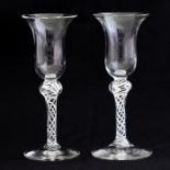 A pair of 18th Century style clear glass wines, 20th Century, bell bowls, double opaque twist