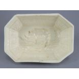 A late eighteenth century creamware jelly mould on three feet, c. 1790. It depicts a rhinoceros in a