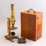 A late 19th Century brushed brass monocular microscope, in a fitted box with a few accessories and