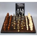 A 20th century cast composition "Lewis" chess set with decorative wooden board.