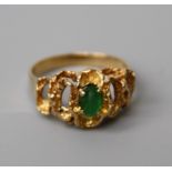A single stone emerald ring, the oval emerald in pierced undulating mount. 5.7g, stone scuffed and