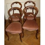 A set of Four Victorian, mahogany balloon back side chairs with stuffover seats and slender French