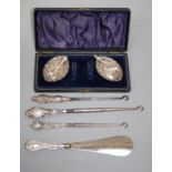 Three silver handled button hooks a shoe horn and a cased pair of navette shape silver salts with