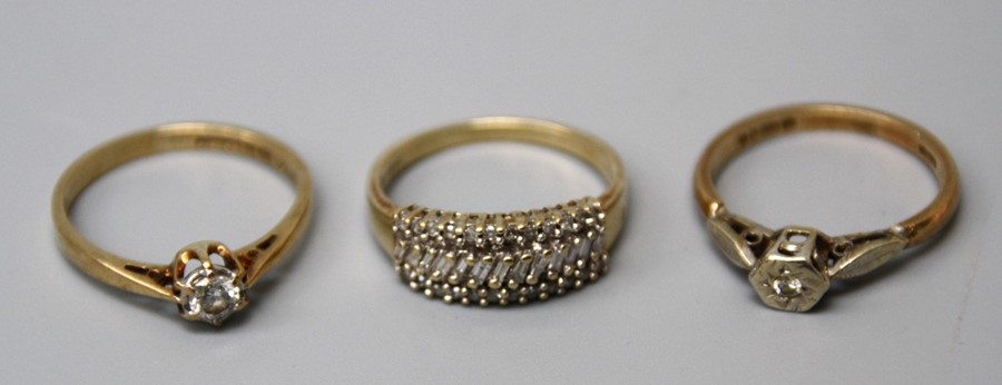 A three row diamond ring, with a band of obliquely set baguette diamonds between two rows of