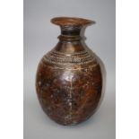 A large probably Tibetan  beaten copper vessel of heavy baluster form with punched decoration and