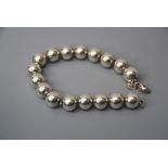 A Tiffany & Co silver bracelet, formed as a row of spherical beads, on a sprung clasp,