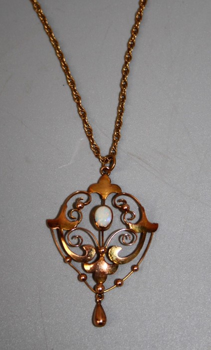 An Edwardian opal set negligee pendant, the central oval opal within pierced scrolling mount to a