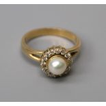 A pearl and diamond cluster ring, the central pearl wothn a border of brilliant cut diamonds to