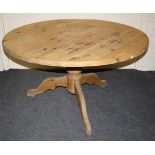 A circular pine breakfast table with broad tripod base. 137 diam