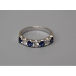 A seven stone half hoop sapphire and diamond ring, the circular cut sapphires and brilliant cut