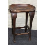An early 20th century saddle seated mahogany stool with cabriole legs
