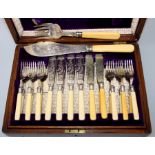 An oak cased set of twelve EPNS ivory handled fish knives and forks together with servers. Each with