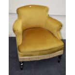 An early 20th century low armchair with stuff-over upholstery. Raised on turned and inlaid