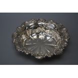 An early 20th century  circular silver fruit bowl with raised  vitruvian scroll and floral rim. 28cm