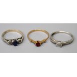 A three stone sapphire and diamond half hoop ring, a diamond cluster ring and a single stone ruby