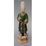 An old Chinese terracotta tomb figure  of an attendant with remains of sancai glaze and poly-
