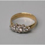 A three stone half hoop diamond ring, the graduated brilliant cut diamonds in rub over settings,