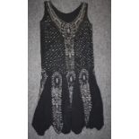 A 1920's black beaded evening dress with dropped waist, crepe type material. Some beads missing