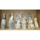 A Lladro figure of a young lady wearing a strapless gown holding a wide brimmed hat, together with t