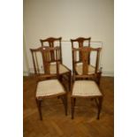 A set of four Edwardian mahogany bedroom chairs, each with floral tapestry upholstered seat.