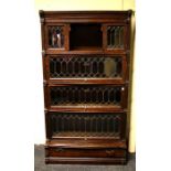 A Globe Wernicke oak six section modular bookcase with fielded panels, leaded glazing and drawer