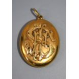 An unmarked late Victorian gold oval locket, with applied monogram to front, and photograph