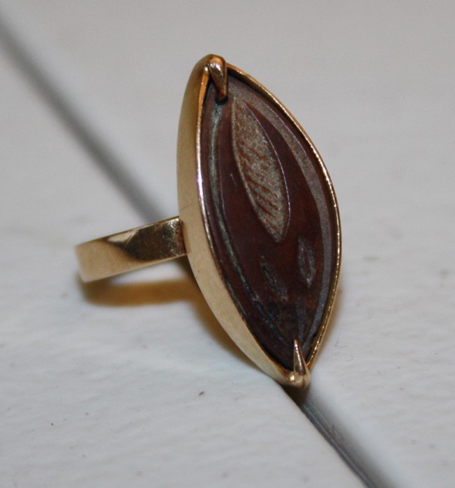 An African engraved husk ring navette shaped in surround mount to plain band. 4.7g gross weight