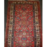 A red ground Hamadan runner with all-over "Herat Fish" scheme within meandering floral borders and