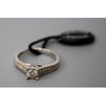 A single stone diamond ring, the brilliant cut diamond in scalloped mount to tapering diamond