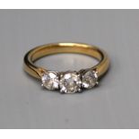 An 18ct three stone diamond ring, claw set round brilliant cut stones, the centre stone of 0.50ct,