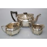 Charles Boyton and Sons, a silver three piece tea service of oval ribbed panel form, each on ball