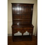 A Geo III style, reproduction oak pot-board dresser and rack fitted two short frieze and two spice