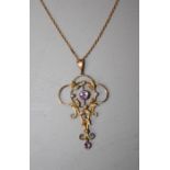 An Edwardian gold openwork pendant of organic form set with pale amethysts and seed pearls, the