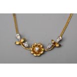 A two gold 9ct gold and diamond pendant, the centre with diamond set flower head motif and scrolling